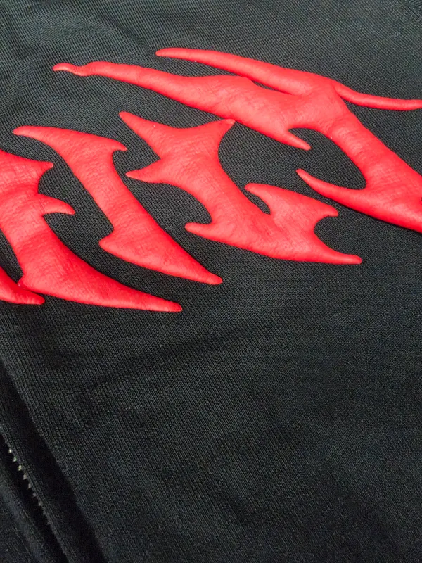 Close-up of raised red artwork on a dark garment