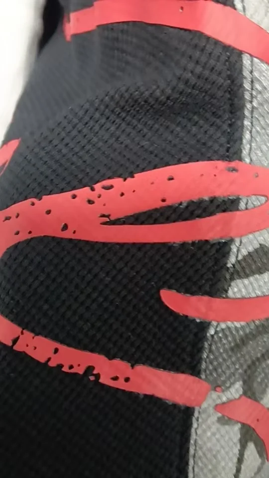 High-density screen-print reference with red graphic lines on dark textured fabric