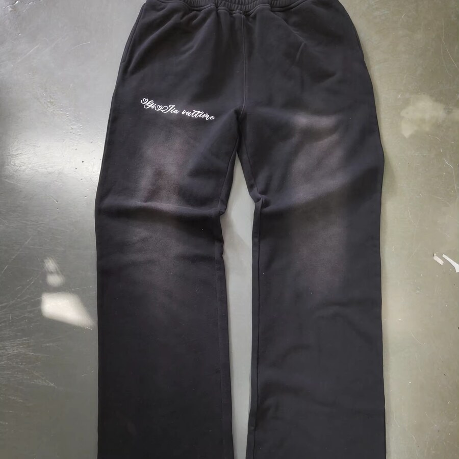Dark sweatpants sample with an elastic waist and thigh embroidery