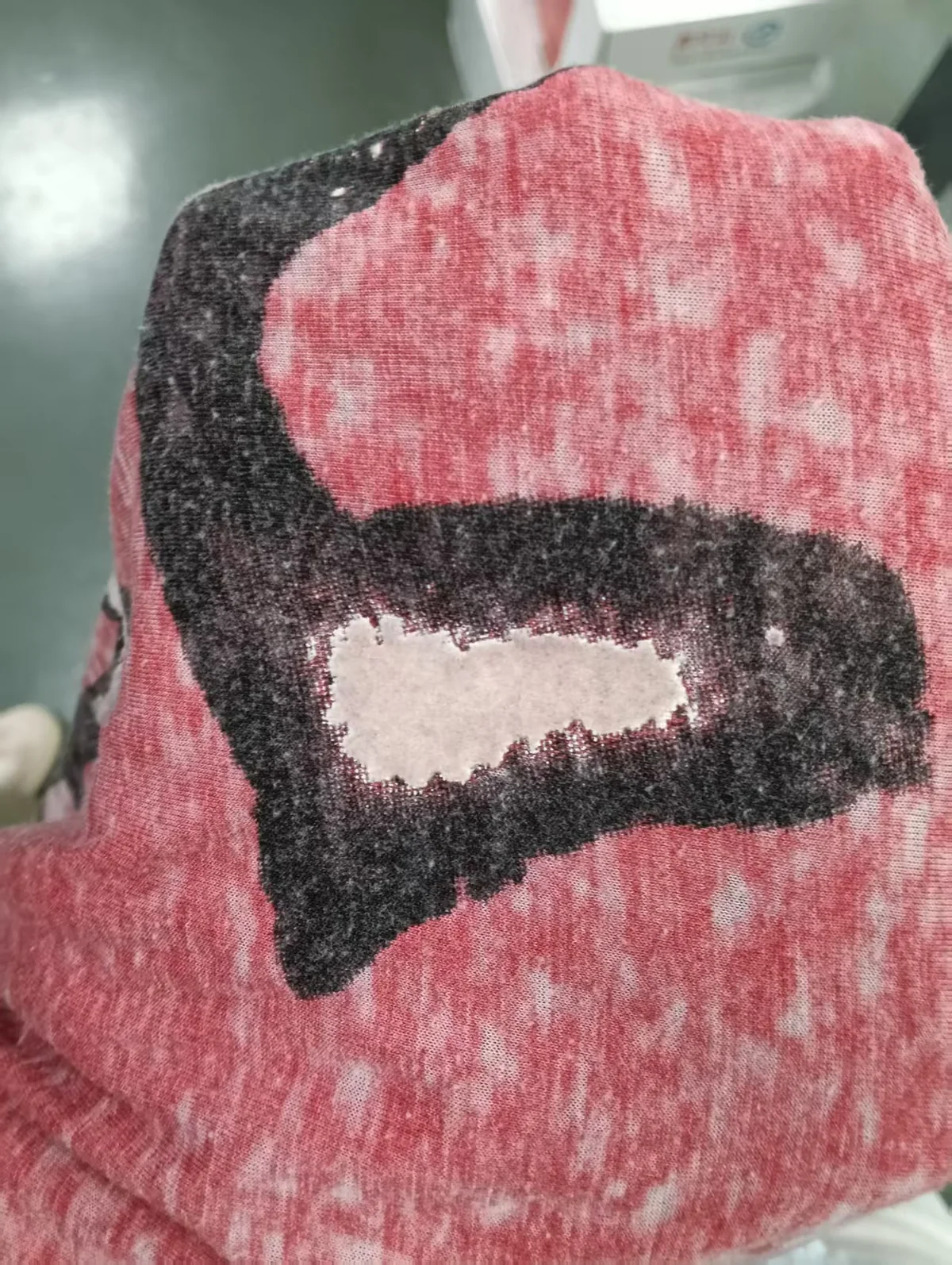 Flock-finish reference with a textured dark motif on washed pink fabric