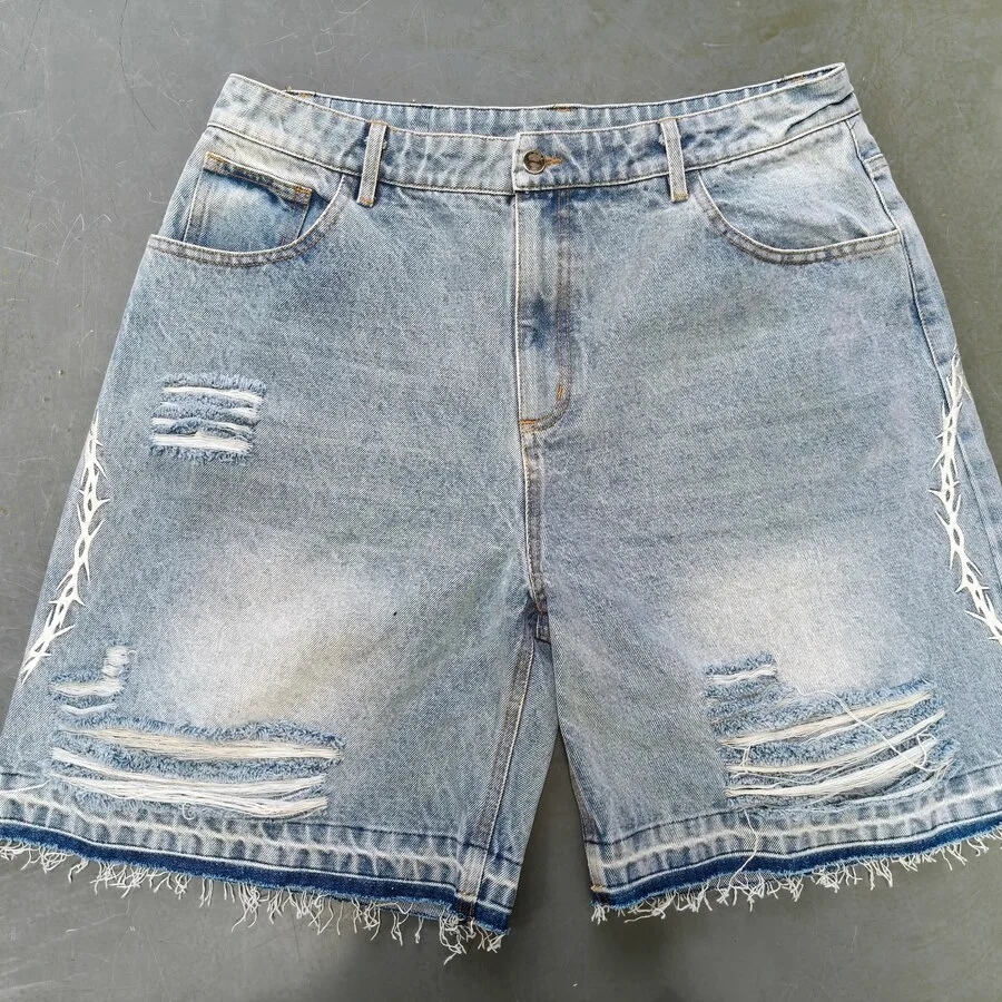 Light-washed denim shorts sample with distressed areas and faded colour