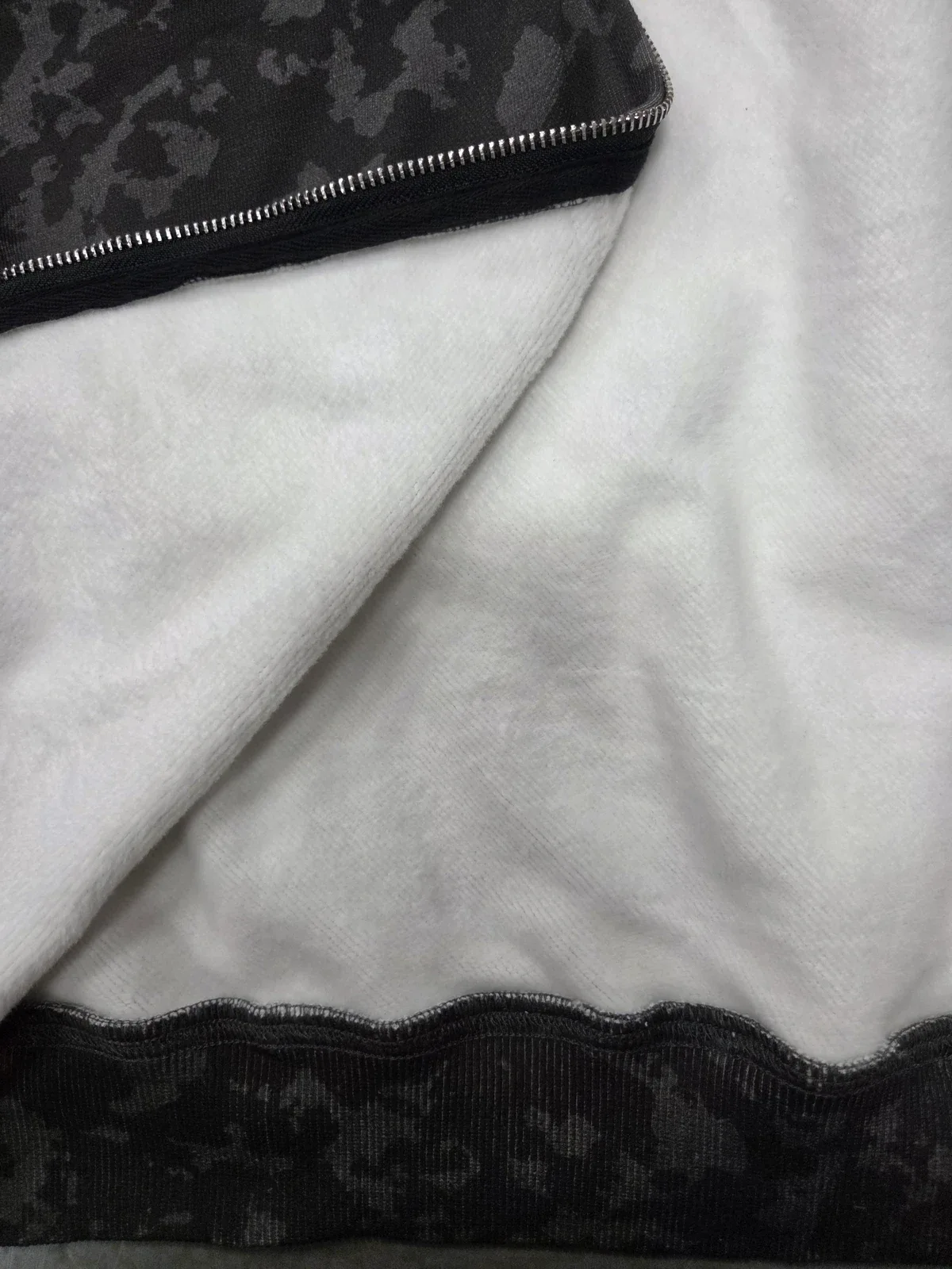 Actual white brushed interior beside a zipper and dark patterned fabric