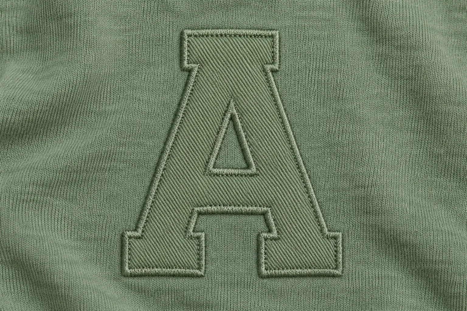 Sage twill letter on matching sage jersey with subtle texture contrast and matching edge stitches