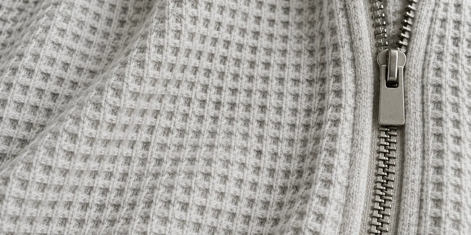 Heavy waffle-knit thermal fabric next to a metal zipper